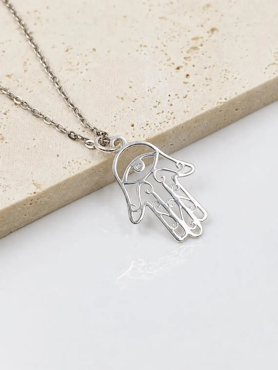 Close-up of sterling silver Hamsa pendant showing minimalist 925 silver detailing